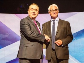 Scotland’s First Minister Alex Salmond (L) and leader of the Better Together campaign and former minister Alistair Darling (R) shake hands ahead of the STV live television debate on Scottish independence in Glasgow, Scotland on August 5, 2014.