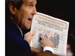 Secretary of State John Kerry points to a photograph on the front page of the Wall Street Journal as an example of cooperation among Arab countries as he testifies on Capitol Hill in Washington on Sept. 17, 2014, during a Senate Foreign Relations Committee hearing on the U.S. strategy to defeat the Islamic State group.