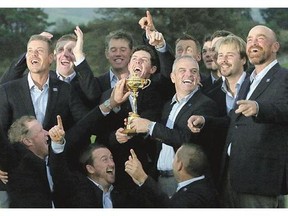 Europe team captain Paul McGinley, holding the trophy, and his team celebrate after winning the Ryder Cup on Sunday.