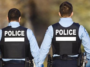 Two SPVM police officers walk on Cedar ave. in Montreal on Friday, December 16, 2011.