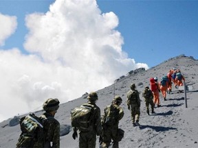 This handout picture taken by Joint Staff on September 28, 2014 and released on September 29 shows Japan's Self Defense Force soldiers and rescue workers searching for survivors and missing climbers on the ash covered top of Mount Ontake at Nagano prefecture, one day after Japan's volcano Ontake erupted in central Japan, which straddling Nagano and Gifu prefecture. The grisly operation resumed to recover bodies after at least 31 people were believed killed when a Japanese volcano erupted, as survivors tell of people dying in front of them as tonnes of ash and rocks thundered from the sky.  AFP/Getty Images