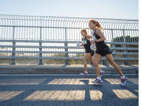 Twins jog as they warm up before the start of the 24th Montreal Marathon on the Jacques-Cartier bridge in Montreal on Sunday, September 28, 2014.