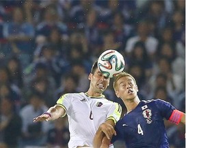 Venezuela’s Gabriel Cichero, left, and Japan’s Keisuke Honda fight for the ball during their international friendly soccer match in Yokohama, south of Tokyo, Tuesday, Sept. 9, 2014.