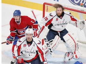 Washington Capitals goalie Braden Holtby loses his mask after being hit by Montreal Canadiens Brendan Gallagher, left, behind Capitals Brooks Orpik during National Hockey League pre-season game in Montreal Sunday Sept. 28, 2014.