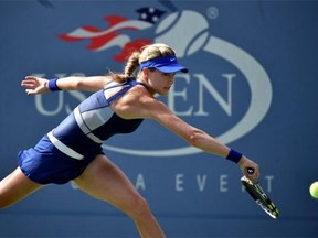 Westmount’s Eugenie Bouchard returns a shot to Ekaterina Makarova of Russia during their U.S. Open women’s singles match Monday in New York.