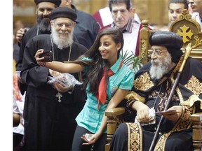 A young copt takes a selfie with Pope Tawadros II of the Coptic Orthodox Church, left, as he was at St Marc’s Coptic Church in Montreal, Saturday, Sept. 20, 2014.