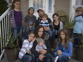 Tara Lawson (bottom centre) with her family in St-Lazare. The mother of 8 is suing the Lakeshore General Hospital and two of its doctors.