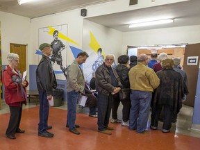 Voters lined up and waited as long as 90 minutes to vote at St. Monica Elementary School during the advance polls for school board election in Montreal on Sunday, Oct. 26, 2014.