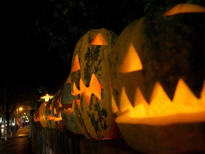 A customer looks at pumpkins carved as grimacing faces with candles inside in a street of Tirana on October 30, 2014, one day before Halloween. AFP PHOTO / GENT SHKULLAKUGENT SHKULLAKU/AFP/Getty Images