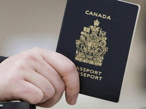 A passenger holds his Canadian passport before boarding a flight in Ottawa on Jan 23, 2007.