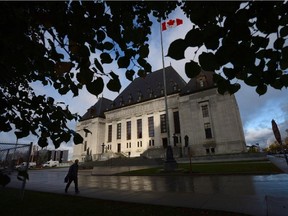 A pedestrian walks past the Supreme Court of Canada in Ottawa, Oct. 18, 2013.