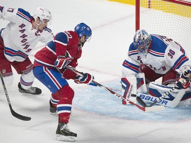 New York Rangers goaltender Henrik Lundqvist makes a save against Montreal Canadiens' Alex Galchenyuk, centre, as Rangers' Ryan McDonagh, left, defends during second period NHL hockey action in Montreal, Saturday, October 25, 2014.