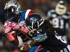 Alouettes running-back Chris Rainey is tackled by Argonauts' Alex Suber during CFL game at Toronto's Rogers Centre on Oct. 18, 2014.