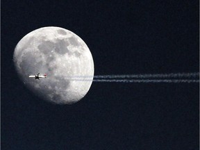 An airplane passes in front of the moon, Tuesday May 21, 2013, over Philadelphia.