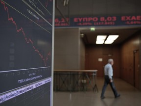 An employee walks past a screen showing a tumbling index at the Athens Stock Exchange on Wednesday Oct. 15, 2014. Concerns that the Greek government could collapse next year, putting its bailout program in danger, caused a massive sell-off in the country's stock and bond markets on Wednesday, with the main stock index down 9.8 percent. The plunge follows a loss of 5.7 percent the previous day and brings the stock market to its lowest level in 14 months.