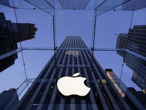 In this Sept. 5, 2014 photo, the Apple logo hangs in the glass box entrance to the company's Fifth Avenue store, in New York. Apple on Wednesday, Oct. 8, 2014 sent invites to an Oct. 16 event during which it�s expected to show off new models of its popular iPad and an update to its Mac OS system.(AP Photo/Mark Lennihan) ORG XMIT: NYBZ140