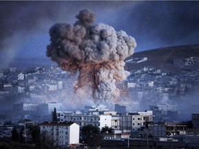 An explosion rocks Syrian city of Kobani during a reported suicide car bomb attack by the militants of Islamic State (ISIS) group on a People's Protection Unit (YPG) position in the city center of Kobani, as seen from the outskirts of Suruc, on the Turkey-Syria border, October 20, 2014 in Sanliurfa province, Turkey.