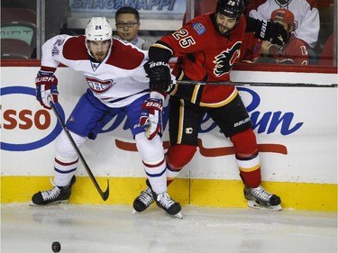 The Canadiens' Jarred Tinordi and the Flames' Brandon Bollig chase the puck during first-period action in Calgary, Tuesday, Oct. 28, 2014.