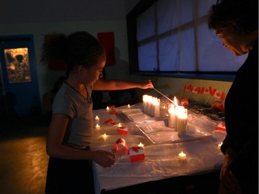 Caitlyn McIntyre lights a candle.