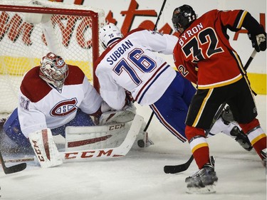 Carey Price and P.K. Subban cover the puck as Calgary Flames' Paul Byron closes in during second-period action in Calgary on Tuesday, Oct. 28, 2014.