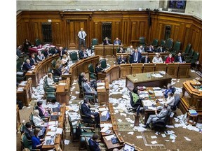 Montreal Mayor Denis Coderre, standing, speaks during a City Council meeting in a room littered with papers from an earlier protest by the firefighter's union at Montreal city hall in Montreal on Monday, August 18, 2014. Four  Montreal police commanders have been suspended without pay for their inaction during the incident . (Dario Ayala / THE GAZETTE)
