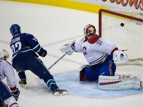 The Canucks' Daniel Sedin scores the winning goal against Canadiens goalie Carey Price during overtime in Vancouver on Oct. 30, 2014.