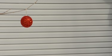 A lone Christmas tree decoration hangs outside on a winter's day in February.