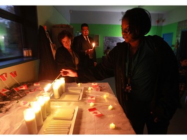 Keisha Loftman, assitant to the executive director of the Boys and Girls Club of Lachine, lights a candle.