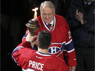 Former Montreal Canadiens goaltender Ken Dryden passes the torch to current Hab Carey Pice during ceremony prior to home opener against the Boston Bruins in Montreal Thurssday October 16, 2014.