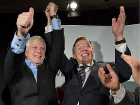Coalition Avenir Québec elected candidate François Paradis, left, celebrates his victory in a by-election with CAQ Leader François Legault in Levis, Que., on Monday, Oct. 20, 2014.