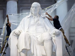 Benjamin Franklin started each day with a half hour “air bath” — standing naked by an open window to stimulate his brain. Above, workmen wrap a statue of Benjamin Franklin in protective cover in preparation for upcoming construction, Tuesday, Aug. 20, 2013, at the The Franklin Institute in Philadelphia.