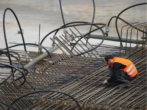 A workers binds steel reinforcement rods at a construction site on October 14, 2014 in Berlin, Germany.