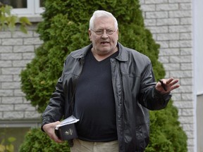 Gilles Rouleau, father of Martin Rouleau, named by several media outlets citing law enforcement sources as the suspect who drove a vehicle into two soldiers on Monday, walks past media at his house in Saint-Jean-sur-Richilieu, Que., Tuesday, Oct.21, 2014.
