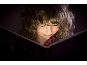 Happy child reading book. Stock art for books for kids column. Credit: Fotolia.