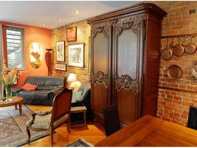 A view of the dining and living rooms, with the central piece being a several centuries' old armoire from Normandy in Renee Lescop's condo Thursday, August 28, 2014 in Montreal. Her ground floor condo is one of a group of apartments built a century ago.