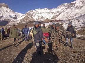 In this photo provided by the Nepalese army, soldiers carry an avalanche victim before he is airlifted in Thorong La pass area, Nepal, Wednesday, Oct. 15, 2014.