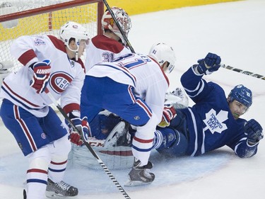 Toronto Maple Leafs' James van Riemsdyk, right, is dragged down by Montreal Canadiens' Alexei Emelin, as goaltender Carey Price, and Lars Eller defend during first period NHL action in Toronto on Wednesday, October 8, 2014. Emelin received a penalty on the play.