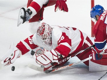 Detroit Red Wings goaltender Jimmy Howard, left, makes a save against Montreal Canadiens' Andrei Markov during second period NHL hockey action in Montreal, Tuesday, October 21, 2104.