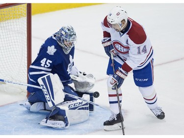 Toronto Maple Leafs goaltender Jonathan Bernier, left, makes a save on a shot by Montreal Canadiens' Tomas Plekanec during second period NHL action in Toronto on Wednesday, October 8, 2014.