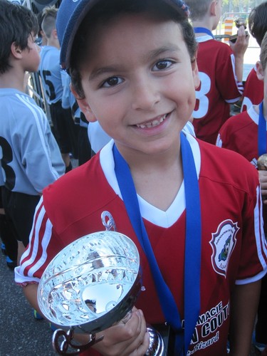 Julian holds the silver cup after soccer finals.