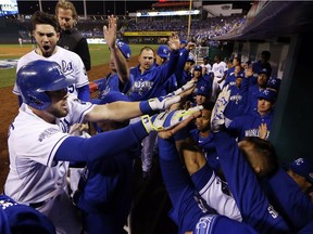 Kansas City Royals' Mike Moustakas is congratulated after hitting a home run during the seventh inning of Game 6 of baseball's World Series against the San Francisco Giants Tuesday, Oct. 28, 2014, in Kansas City, Mo.