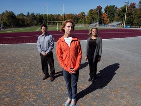Elizabeth Harder, centre, widow of Bryan Liew, stands on running track with Patrick Lepage and  Claudia Wagner at Westwood Junior High in St-Lazare.