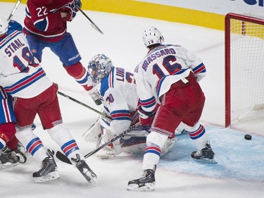 New York Rangers goaltender Henrik Lundqvist (30) is scored on by Montreal Canadiens' Lars Eller, second left, as Rangers' Martin St. Louis, left, Marc Staal (18) and Derek Brassard (16) defend during second period NHL hockey action in Montreal, Saturday, October 25, 2014.