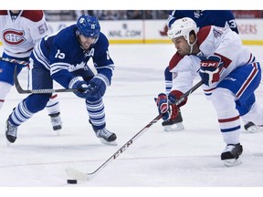 Toronto Maple Leafs forward Joffrey Lupul, left, balltle for the loose puck against Montreal Canadiens defenceman Mike Weaver, right, during second period NHL hockey action in Toronto on Saturday, March 22, 2014. The Leafs and Canadiens will once again kick off the NHL season.THE CANADIAN PRESS/Nathan Denette ORG XMIT: CPT122