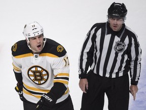 Boston Bruins' Milan Lucic reacts as he is escorted off the ice by linesman Michel Cormier after receiving a minor penalty late in a game against the Canadiens at the Bell Centre on Oct. 16, 2014. The Canadiens beat the Bruins 6-4.