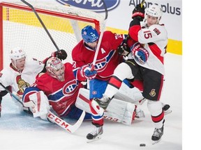 Montreal Canadiens defenceman Andrei Markov, second from right, and Senators’ Zack Smith, right, fight for the puck as Canadiens goalie Carey Price, centre, falls, during the third period of their preseason NHL hockey match at the Bell Centre in Montreal on Saturday, October 4, 2014.