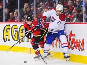 CALGARY, AB - OCTOBER 28: Matt Stajan #18 of the Calgary Flames battles for the puck against Rene Bourque #17 of the Montreal Canadiens during an NHL game at Scotiabank Saddledome on October 28, 2014 in Calgary, Alberta, Canada.