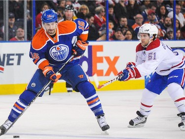 Teddy Purcell of the Edmonton Oilers skates with the puck as David Desharnais of the Montreal Canadiens defends during action on Monday, Oct. 27, 2014. in Edmonton.