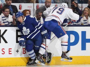 Andrei Markov #79 of the Montreal Canadiens lays a hit on Brandon Kozun #67 of the Toronto Maple Leafs in their NHL season opener at the Air Canada Centre on October 8, 2014 in Toronto, Ontario, Canada.