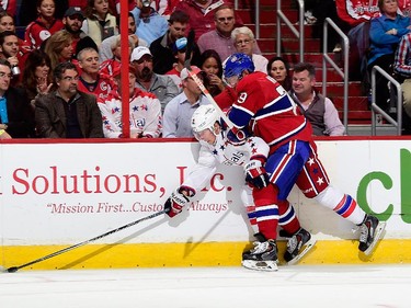 Nicklas Backstrom of the Washington Capitals is checked against the boards by Andrei Markov of the Montreal Canadiens in the second period during the Capitals NHL season opener at Verizon Center on October 9, 2014, in Washington, DC.